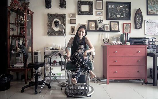 Female tattoo artist in studio with equipments