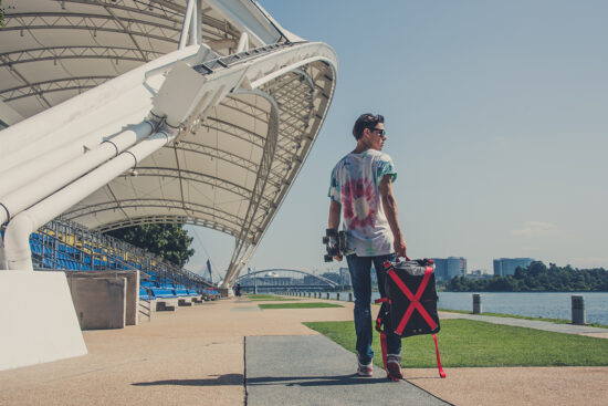 Travel photoshoot with luggage near stadium architecture