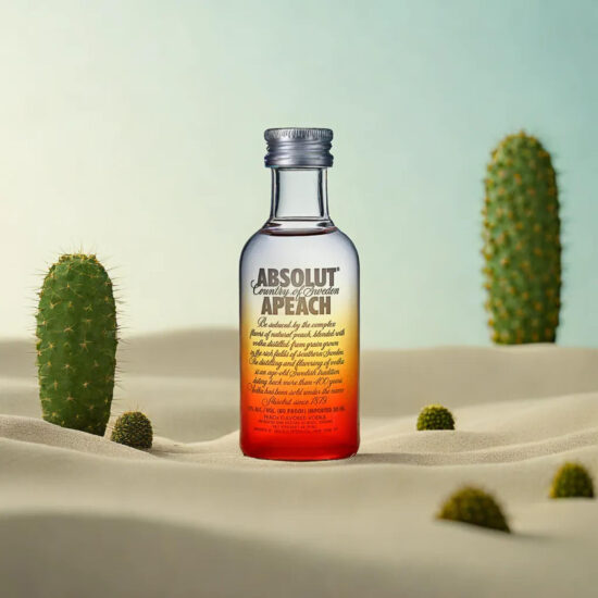 Absolut Vodka bottle with desert-style props – beverage photography.