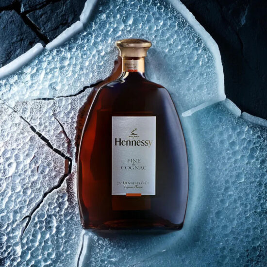 Hennessy Premium liquor bottle with glass reflection – creative beverage photography.