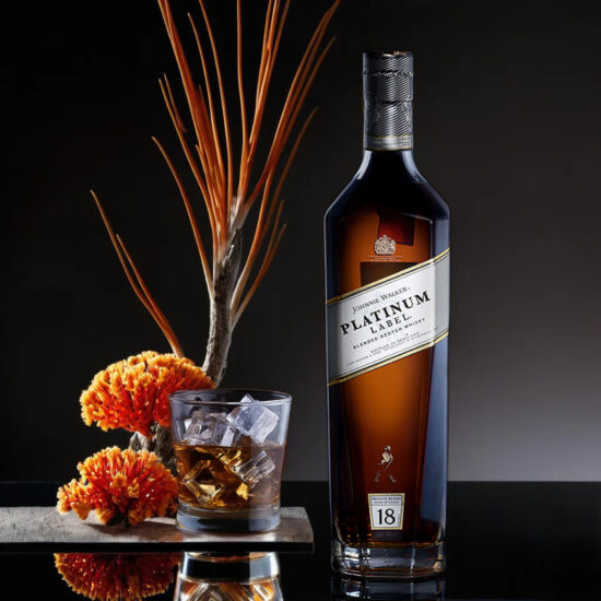 Premium whiskey bottle with orange garnish – commercial liquor photography.