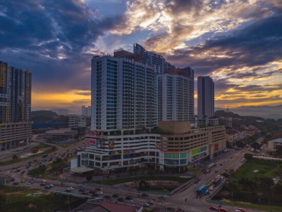 Modern high-rise building with mall in city in early morning