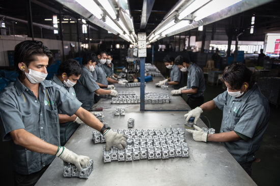 Factory workers assembling components on production floor