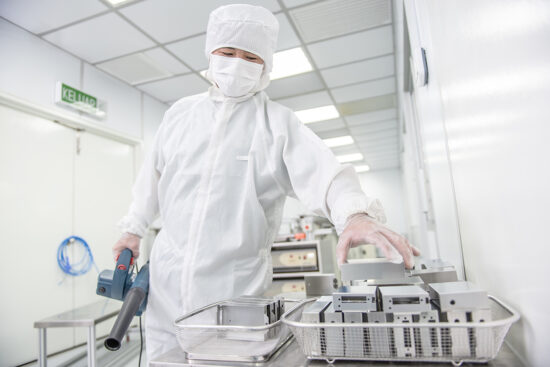Worker in cleanroom environment operating machinery