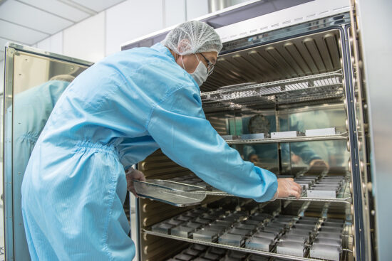 Worker in protective suit handling industrial equipment