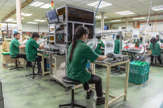 Workers assembling electronic devices on production line