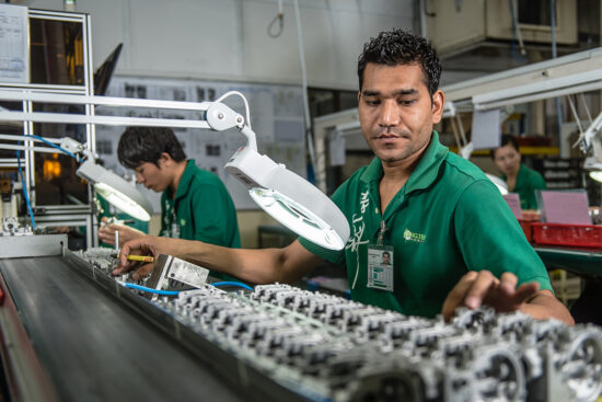 Worker assembling components in factory production line