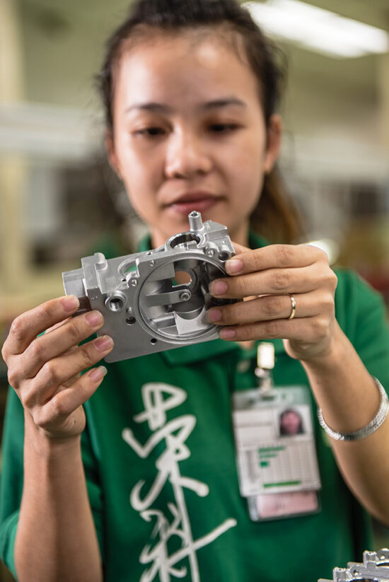 Female worker holding small mechanical component