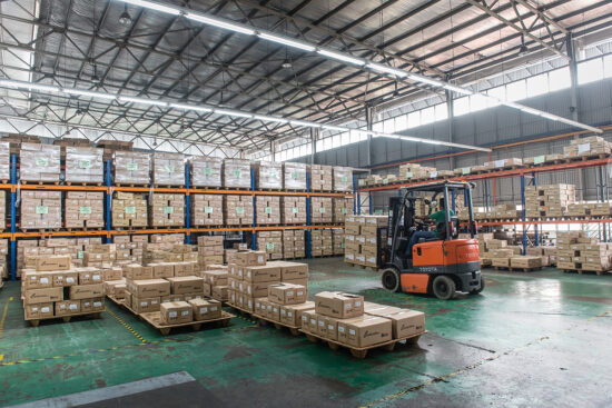 Forklift transporting packed goods in factory