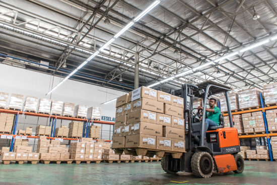 Forklift loading goods in large warehouse