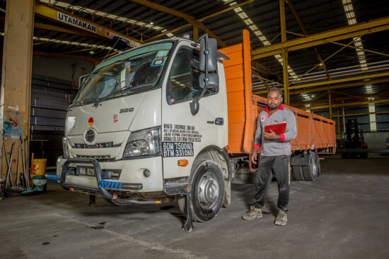 Worker checking list from truck in factory